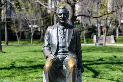 Bronze Statue of Man Sitting in Park