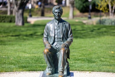 Bronze Statue of Seated Man in Suit