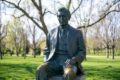 Bronze statue of seated man in park