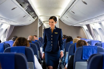 Flight attendant walking airplane aisle