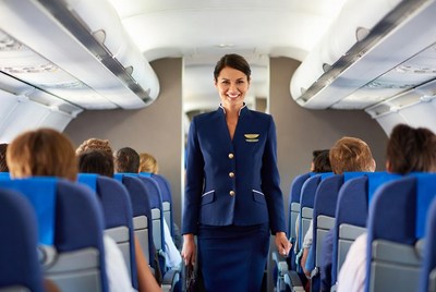 Smiling flight attendant in airplane aisle