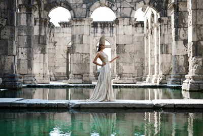 Woman in gold gown at ancient ruins