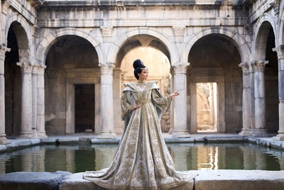 Woman in gold gown at ancient courtyard