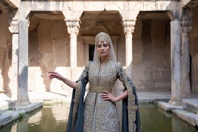 Woman in gold kaftan at ancient courtyard