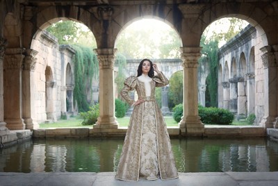 Woman in gold Renaissance gown by arches