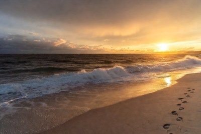 Footprints in sand at sunset beach