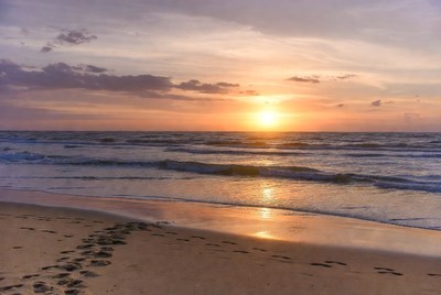 Footprints in sand at sunset beach