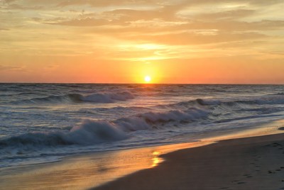 Sunset over ocean waves and beach