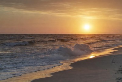 Sunset over ocean waves and beach