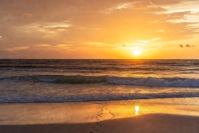 Footprints in sand at sunset beach