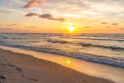 Sunset over beach with footprints