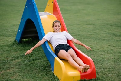 Girl sliding down colorful playground slide
