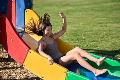 Girl sliding down colorful playground slide