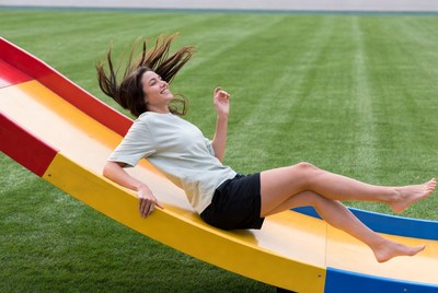 Woman sliding down colorful playground slide