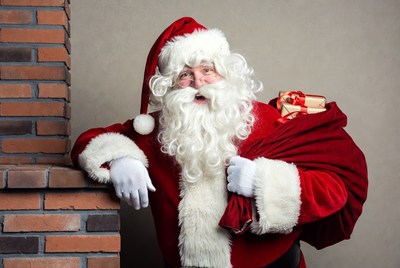 Santa Claus with sack by fireplace