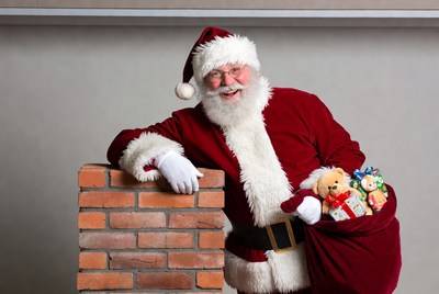 Santa Claus leaning on brick chimney with toys