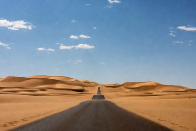 Road through desert dunes