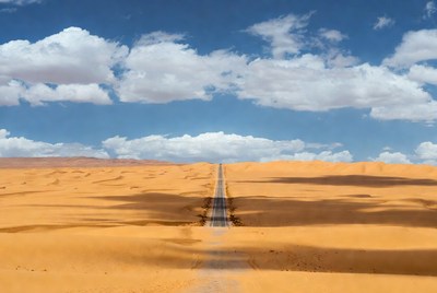 Road through endless desert dunes