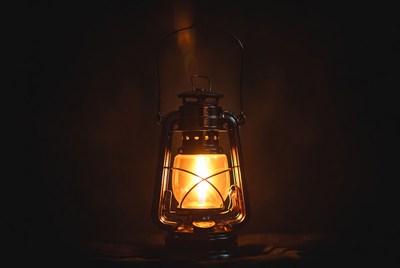 Glowing vintage lantern on black background