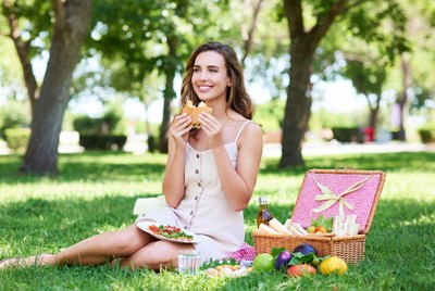 Woman eating sandwich at picnic