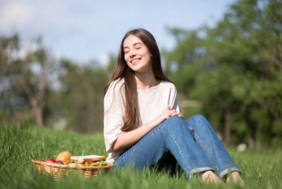 Young woman with picnic basket on grass