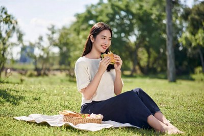 Asian woman eating sandwich picnic