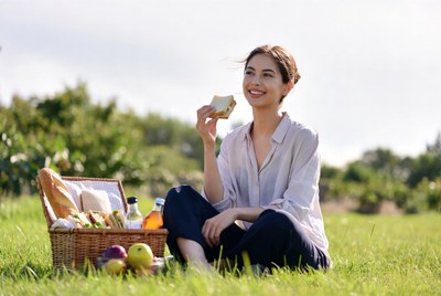 Asian woman eating sandwich picnic
