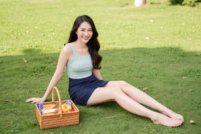 Asian woman with picnic basket on grass