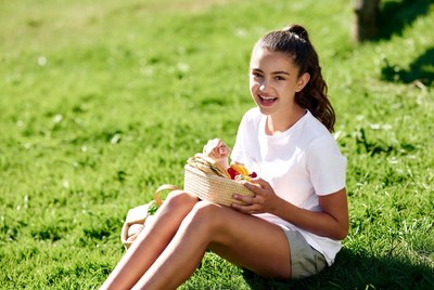 Girl holding fruit basket in grass