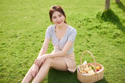 Asian woman with picnic basket on grass