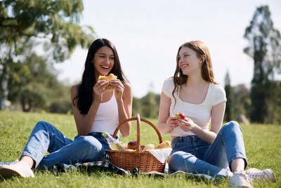 Two women eating picnic in park
