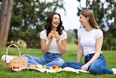 Two women eating picnic in park