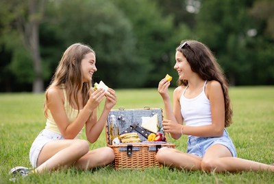 Two girls eating picnic in park