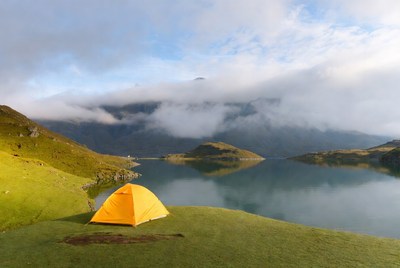 Yellow tent by mountain lake