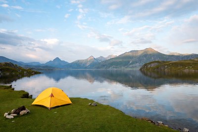 Yellow tent by mountain lake