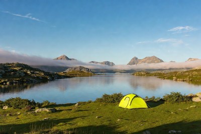 Yellow tent by mountain lake