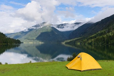Yellow tent by lake and mountains