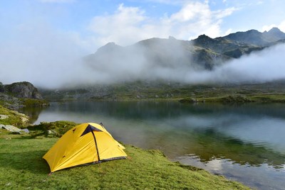 Yellow tent by mountain lake