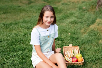 Girl with picnic basket on grass