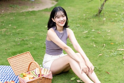 Asian woman with picnic basket on grass