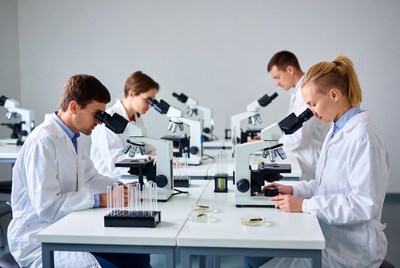 Scientists using microscopes in lab