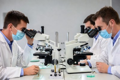 Scientists using microscopes in lab
