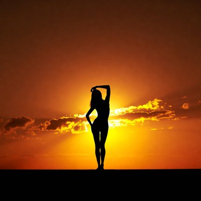 Silhouette of nude woman at sunset