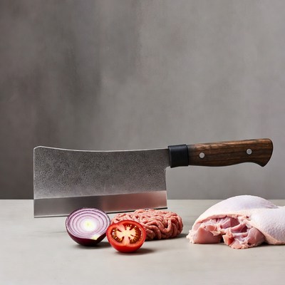 Cleaver with raw chicken and vegetables