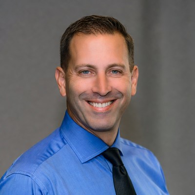 Smiling man in blue shirt and tie