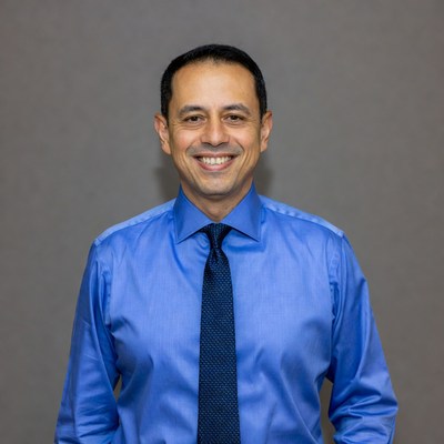 Smiling man in blue shirt and tie