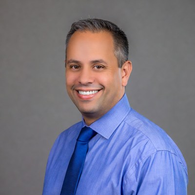 Smiling man in blue shirt and tie