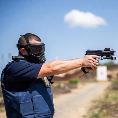 Man shooting pistol with gas mask