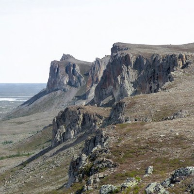 Rugged rocky cliffs over tundra landscape