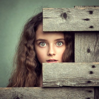 Girl peeking through wooden planks